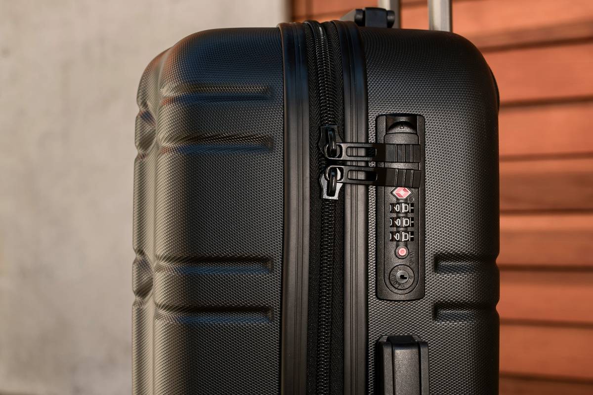 Hard jetsetter case fitting perfectly in airplane overhead bin with internal compression system visible